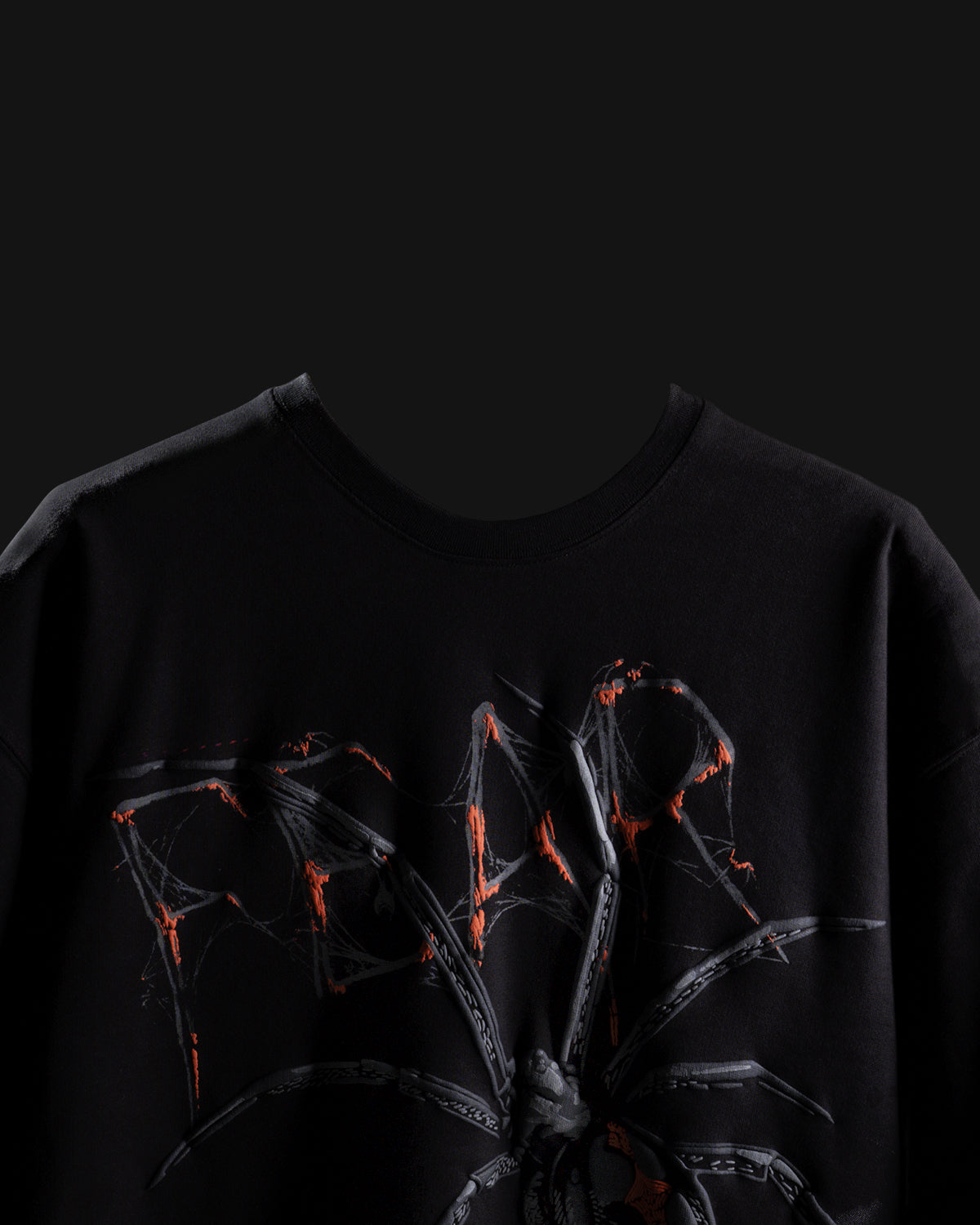 Black t-shirt with a spider web design on a dark background