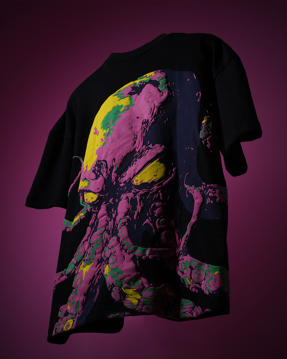 Black t-shirt with colorful graphic design on a pink background