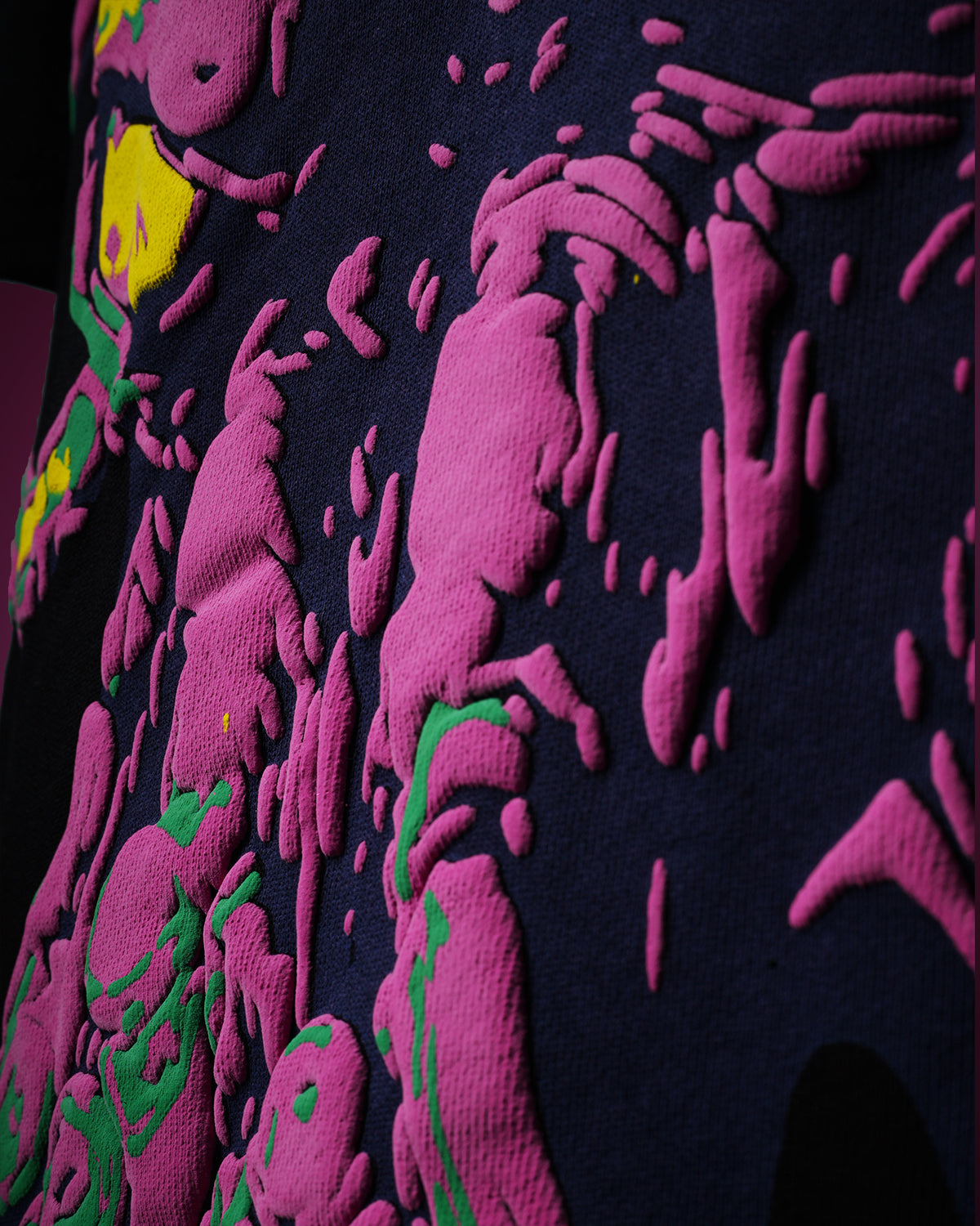 Close-up of a dark fabric with pink and green puff patterns
