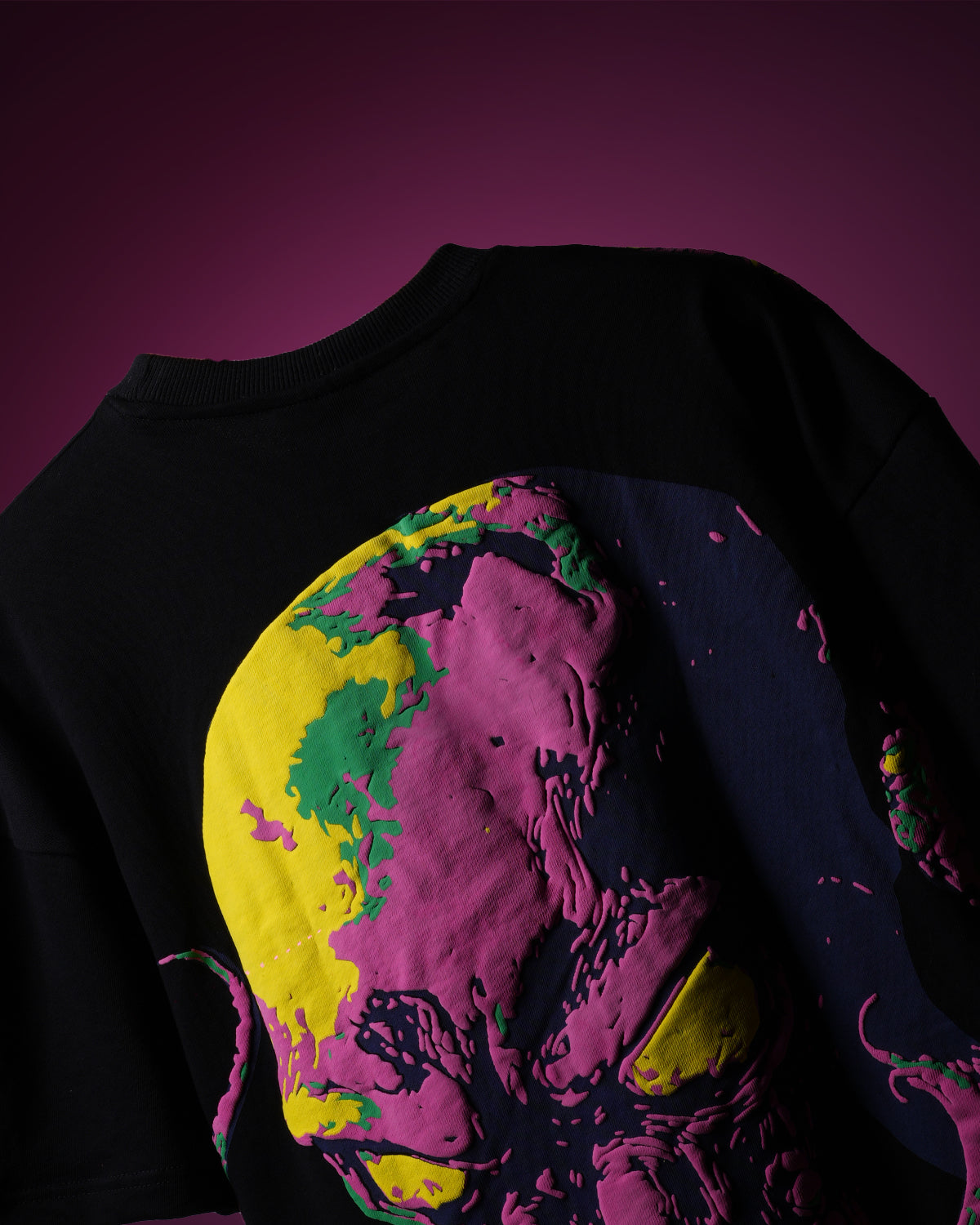 Black t-shirt with colorful graphic design on a pink background